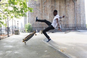 Fototapeta na wymiar Black Boy Skating at Park and Falling Down