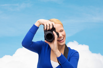 smiling woman taking picture with digital camera