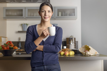 Obraz na płótnie Canvas Glückliche zufriedene Hausfrau trinkt Kaffee