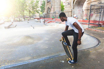 Fototapeta premium Black Boy Skating at Park with Longboard
