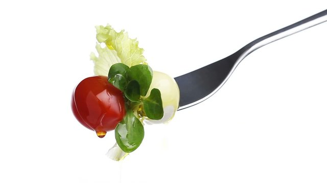 fork lettuce salad leaves, tomato and mozzarella topped with oli
