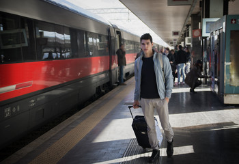Handsome young male traveler in train station