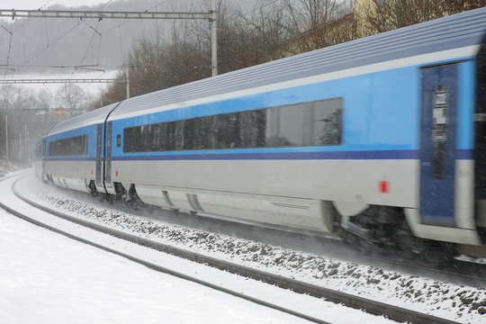 Czech train station at winter with train in a snowstorm