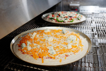 Cheese pizza entering the industrial oven