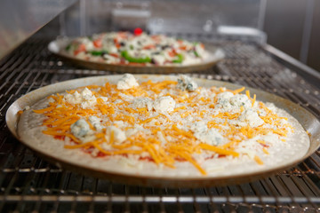 Cheese pizza entering the industrial oven