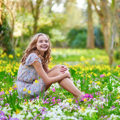 Naklejka na ściany i meble Happy young girl in park on a spring day