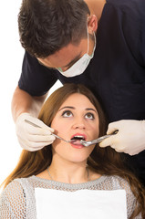 young male dentist examinig beautiful girl's teeth