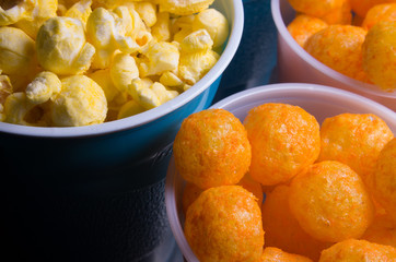 Popcorn and cheesepuffs in plastic cups