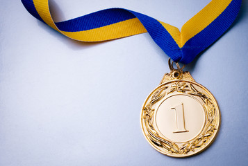 Gold medal on a blue background - obrazy, fototapety, plakaty