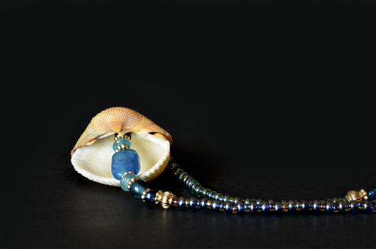 Seashell with blue pearls isolated on black, macro detail