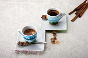 Obraz na płótnie Canvas Two cups of espresso coffee with brown sugar and cinnamon sticks