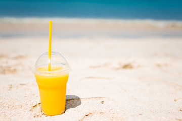Mango cocktail on tropical beach background