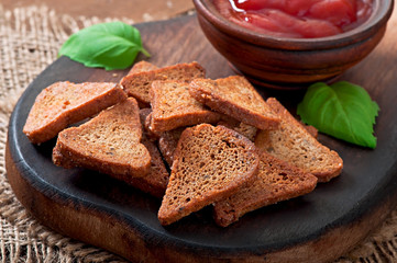 Rye rusks with spicy sauce on a wooden background