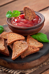 Rye rusks with spicy sauce on a wooden background