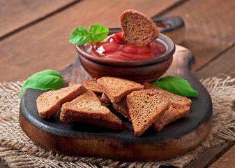 Rye rusks with spicy sauce on a wooden background