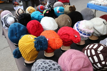 Fototapeta na wymiar caps of all sizes for sale in stand of flea market
