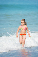 The happy child runs on the seashore