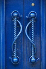 Bright blue door and ornate handles