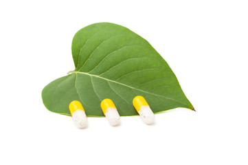 Three capsules on green leaf