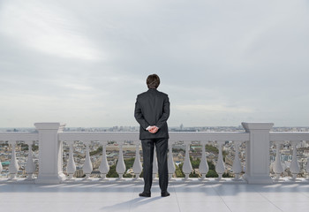 businessman standing on balcony