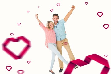 Fototapeta premium Composite image of attractive couple smiling and cheering
