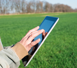 A man holding a digital tablet closeup on nature