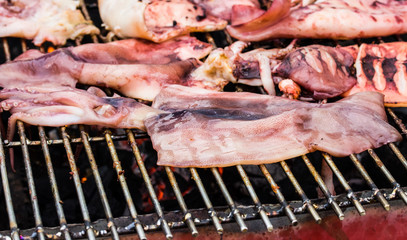 Close up fresh squid barbeque grilled on charcoal stove