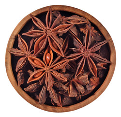 Star anise in a wooden bowl on a white