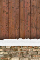 Brick and wood fence  with snowdrift - winter background