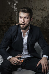 Attraktiver Mann mit Bart, Zigarre und  Whiskey