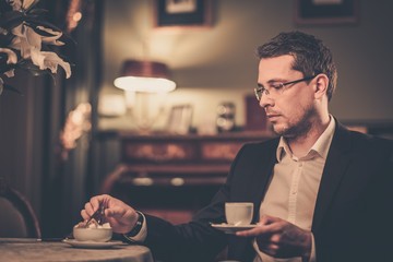 Middle-aged with cup of coffee in luxury vintage style interior