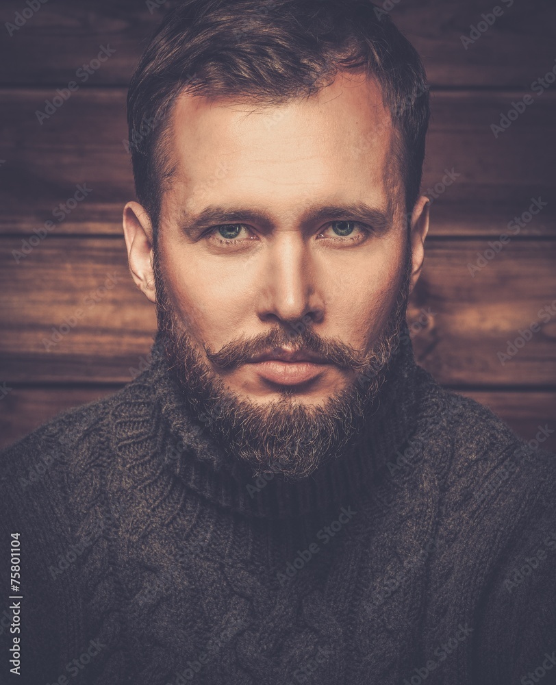 Wall mural handsome man wearing cardigan in wooden rural house interior