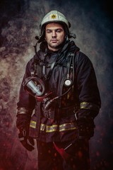 Firefighter with helmet and axe in a smoke