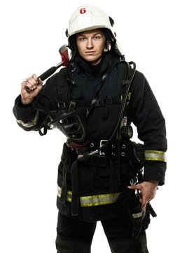 Young firefighter with helmet and axe isolated on white