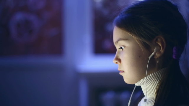 Portrait of child used the computer at night.