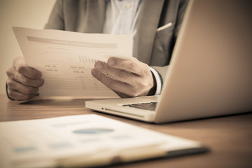 Businessman analyzing investment charts with laptop. Accounting
