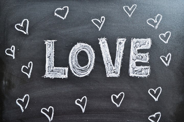The word Love and hearts on a blackboard, background