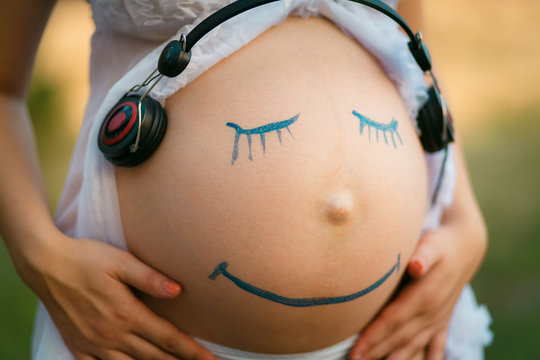 Pregnant woman belly with smiling funny face