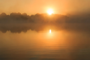 Obraz premium Orange sun rising over lake France