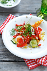 Summer salad with peppers and onion rings in a white plate