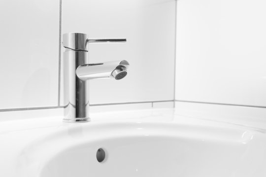 Faucet and white basin in a bathroom