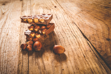Chocolate and nuts on a wooden table in vintage style
