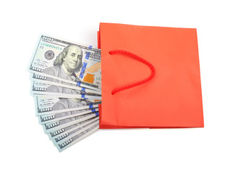 Dollar bills folded in a red paper bag on a white background.