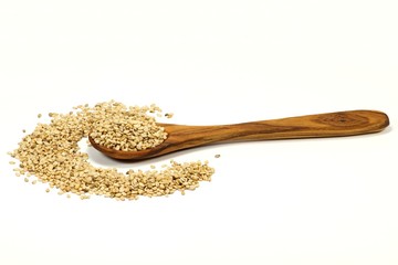 Sesam mit Löffel aus Olivenholz isoliert auf weißem Hintergrund