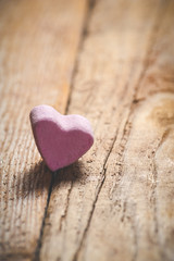 The pink heart on a wooden rustic table as background