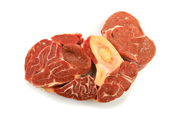 A large piece of red meat with a bone on a white background.