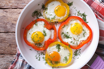 fried eggs in peppers on a pan close-up. top view horizontal