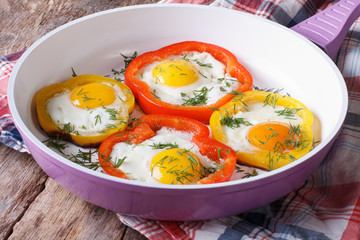 fried eggs with yellow and red peppers in a pan horizontal
