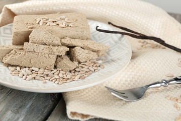 Sunflower halva on plate, on wooden background