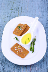 Crispbread with salt, spoon of oil and sprigs of rosemary